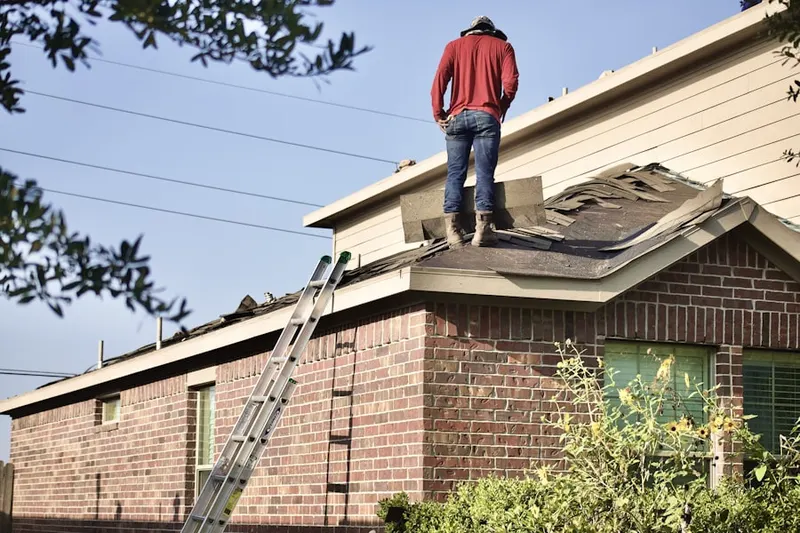 Professional roofer working on a residential roof in North Granby